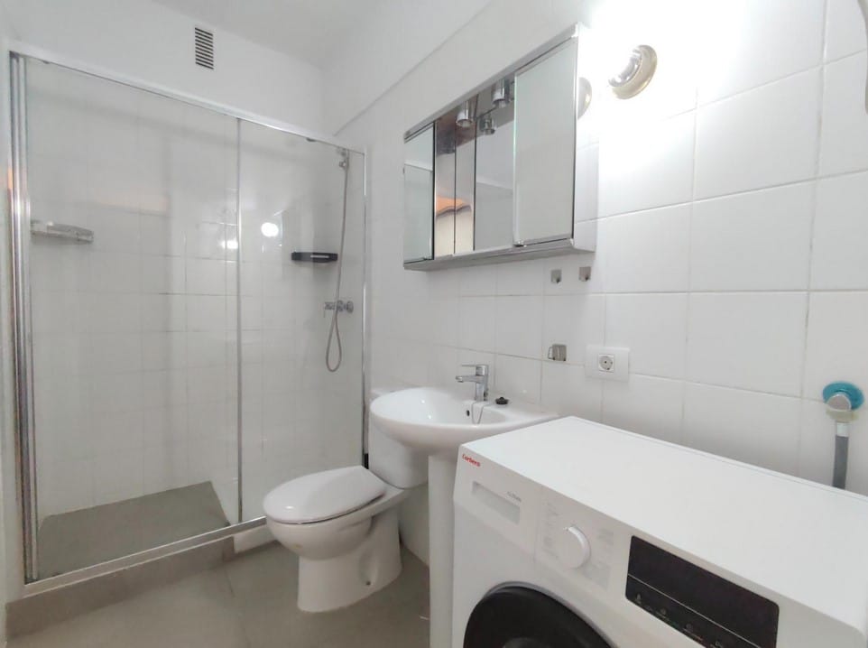 Baño completo con lavadora integrada en apartamento de alquiler en el centro de Santa Cruz de Tenerife.