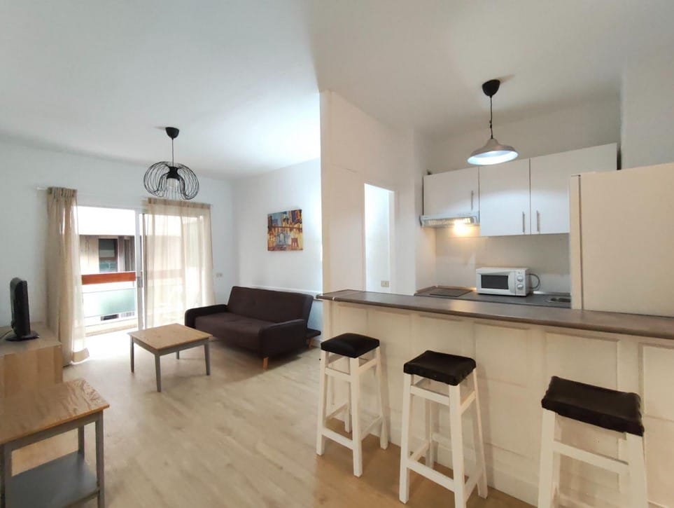 Salón moderno con sofá cama de apertura fácil en apartamento de alquiler en Santa Cruz de Tenerife.
